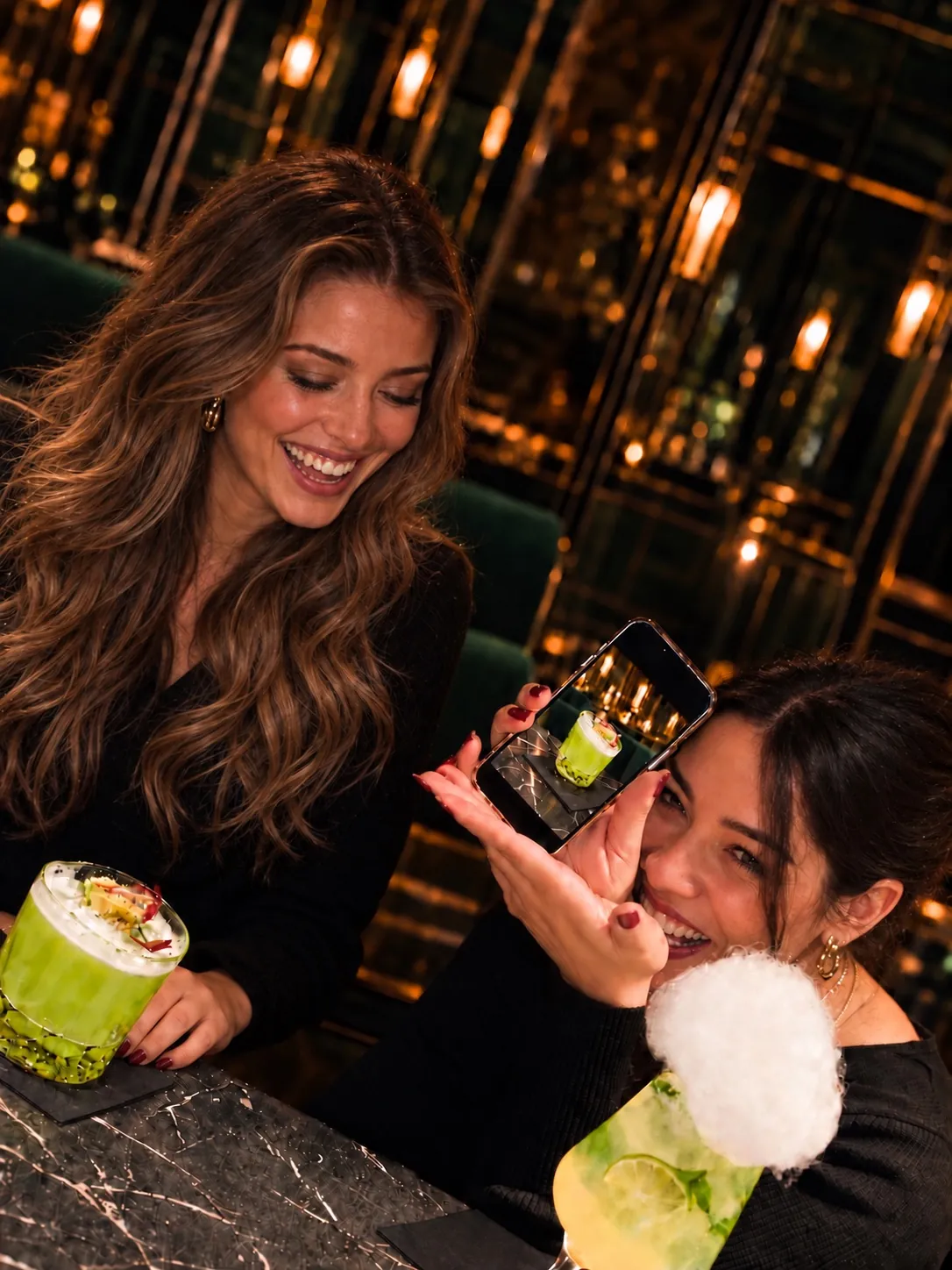The connection: guests laughing while showing a photo of their drink